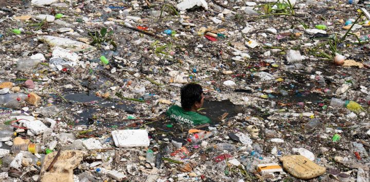 Un trabajador nada entre la basura arrastrada por un río durante las intensas lluvias provocadas por el monzón del suroeste días antes, cerca de un centro comercial en la ciudad de Parañaque, en las afueras de Manila, Filipinas. Inundaciones, desmalezamientos de tierra y accidentes causados por un aguacero de nueve días equivalente a más de un mes de lluvia en algunas zonas han dejado al menos 16 muertos en el norte de Filipinas, según informaron los rescatistas.