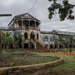 Niños juegan al fútbol frente al antiguo edificio del hospital en Roca Agua-Ize, ubicada en la costa este de Santo Tomé, capital de Santo Tomé y Príncipe. | Foto:DANIEL BELOUMOU OLOMO / AFP