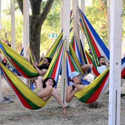 Personas se relajan en coloridas hamacas durante el Festival Sziget en la isla de Óbuda, en Budapest, Hungría. | Foto:ATTILA KISBENEDEK / AFP