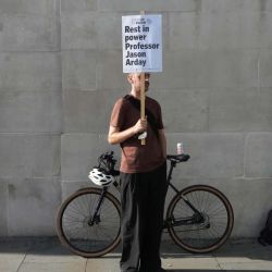 Un simpatizante sostiene una pancarta antes de participar en una vigilia en memoria del fallecido profesor de Cambridge, Jason Arday, en Trafalgar Square, en el centro de Londres, tras su muerte a los 41 años. Arday, el exprofesor de Cambridge hallado muerto en medio de una creciente polémica por acusaciones de plagio académico y exageraciones de su vida personal, ascendió desde orígenes humildes en Gran Bretaña hasta convertirse en una figura académica de gran prestigio. | Foto:CARLOS JASSO / AFP