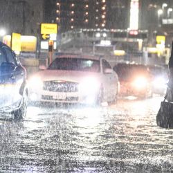 Varios vehículos adelantan a un viajero en una carretera inundada cerca de la estación de metro de Chiba, mientras fuertes lluvias azotaban la zona. Las lluvias torrenciales castigaron el este de Japón, provocando deslizamientos de tierra y cortes de electricidad, y llevando a la autoridad meteorológica a emitir por primera vez la alerta de lluvias torrenciales de máximo nivel para la región. | Foto:Philip Fong / AFP