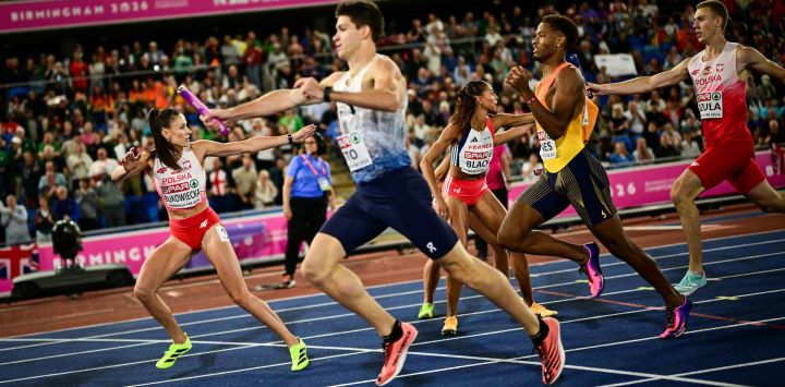 Los atletas se pasan el testigo mientras compiten en la final del relevo mixto 4x400 metros durante el Campeonato Europeo de Atletismo en el Estadio Alexander de Birmingham, Inglaterra.