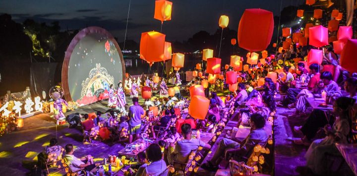 Personas disfrutan de una presentación en un concierto llevado a cabo durante un festival de turismo y cultura con la temática de linternas flotantes por el Festival Qixi, también conocido como el Día de San Valentín chino, en el distrito de Rongchang de la municipalidad de Chongqing, en el suroeste de China.
