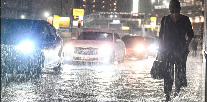 Varios vehículos adelantan a un viajero en una carretera inundada cerca de la estación de metro de Chiba, mientras fuertes lluvias azotaban la zona. Las lluvias torrenciales castigaron el este de Japón, provocando deslizamientos de tierra y cortes de electricidad, y llevando a la autoridad meteorológica a emitir por primera vez la alerta de lluvias torrenciales de máximo nivel para la región.