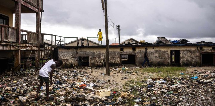 Niños caminan entre los escombros arrastrados por el mar en el Palacio Real, dañado por la erosión costera en Ayetoro, estado de Ondo. La comunidad costera de Ayetoro, en el estado de Ondo, al suroeste de Nigeria, se ha convertido en uno de los ejemplos más visibles del país sobre la vulnerabilidad de las comunidades que viven a lo largo del océano Atlántico ante la erosión costera y el aumento del nivel del mar. Desde principios de la década de 2000, la erosión costera en Ayetoro se ha intensificado progresivamente, con el océano Atlántico invadiendo gradualmente el asentamiento, engullendo casas, escuelas y otras infraestructuras, y obligando a algunos residentes a reubicarse varias veces.