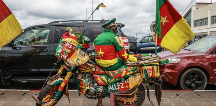 Un motociclista vestido con los colores de Camerún espera sentado en su moto la llegada de la selección nacional femenina al Aeropuerto Internacional de Yaundé Nsimalen, en Yaundé. Camerún se coronó campeona de la Copa Africana de Naciones Femenina (WAFCON) tras derrotar a Malaui por 3-0 en la final disputada en Marruecos.