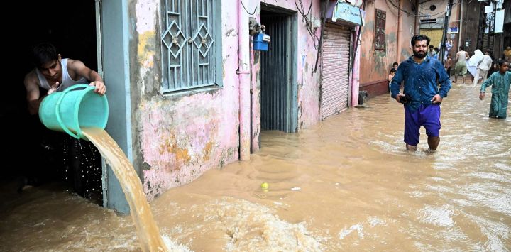 Un residente retira el agua de la inundación de su casa tras las fuertes lluvias en Rawalpindi, Pakistán.