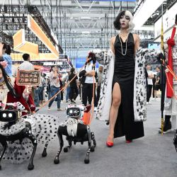 Asistentes disfrazados presentan perros robot de Vbot durante la Conferencia Mundial de Robótica de 2026 en Pekín, China. | Foto:ADEK BERRY / AFP