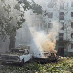 Esta fotografía muestra coches calcinados junto a un edificio residencial dañado en el lugar de un ataque aéreo ruso en Zaporiyia, en el contexto de la invasión rusa de Ucrania. | Foto:Darya Nazarova / AFP
