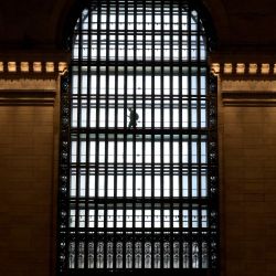 Una persona pasa junto a las ventanas arqueadas palladianas de seis pisos de la Grand Central Terminal, en el lado este del vestíbulo principal, en Nueva York. | Foto:TIMOTHY A. CLARY / AFP