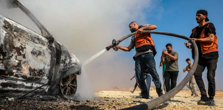 Imagen de bomberos palestinos intentando extinguir el fuego que estalló en un vehículo en el que viajaba el jefe de la Policía de Gaza, Jamal Mahmoud Abu Kamil, tras haber sido blanco de un ataque aéreo israelí en la calle Rashid, en el suroeste de la Ciudad de Gaza.