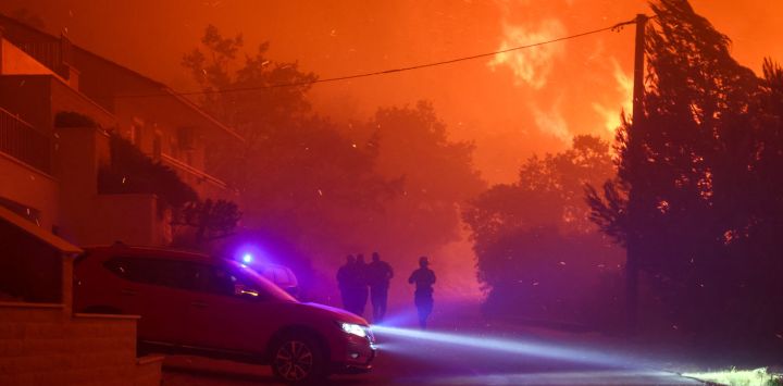 Imagen de bomberos vistos cerca de un incendio forestal de grandes dimensiones en el poblado costero de Omis, Croacia. Alrededor de 1.000 residentes y turistas han sido evacuados después de que un incendio forestal de grandes dimensiones se propagó hasta el poblado costero de Omis, en el sur de Croacia.