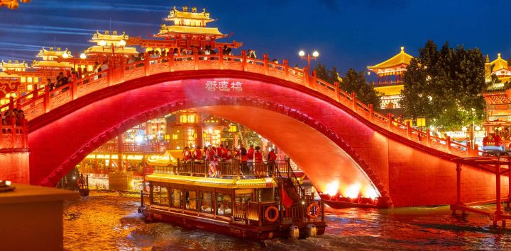 Imagen de turistas recorriendo el área escénica de la Antigua Calle Hetou, en el distrito de Fengnan de la ciudad de Tangshan, en la provincia de Hebei, en el norte de China. Diversas presentaciones incluyendo espectáculos de luces y fuegos artificiales con hierro fundido son exhibidas aquí este verano, dando un impulso al consumo turístico local.