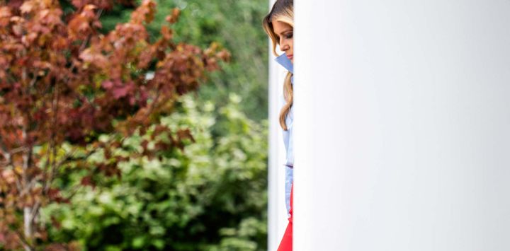 La primera dama estadounidense, Melania Trump, sale entre las columnas al llegar para presentar un evento con IndyCar y FOX Sports con el fin de ampliar las oportunidades académicas para personas que salen del sistema de acogida, en el Jardín de las Rosas de la Casa Blanca, en Washington, D.C..