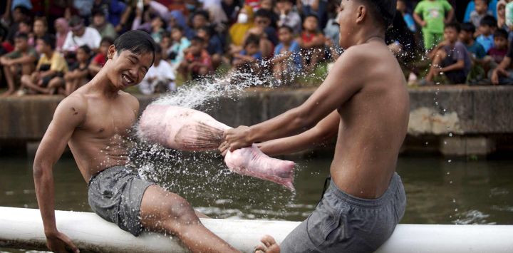 Personas participantes en una pelea de almohadas durante una celebración del 81° aniversario de la fundación de la República de Indonesia, en Yakarta, Indonesia.