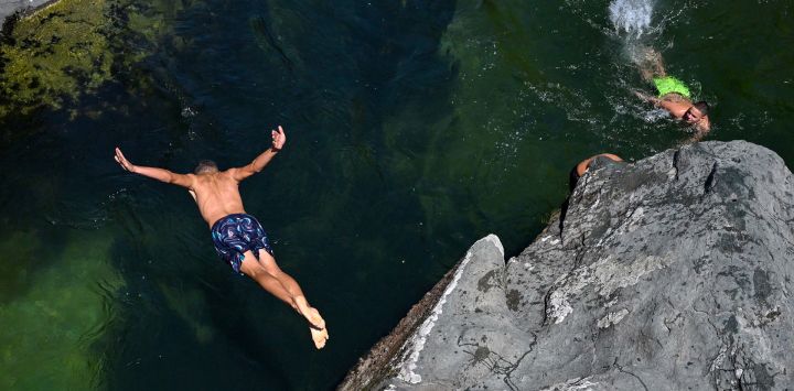 Un hombre se zambulle en el río Treska para escapar del calor de verano, cerca de Skopie, en Macedonia del Norte.