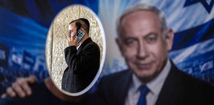 Un miembro del partido Likud aparece en una fotografía tomada frente a un cartel con la imagen del primer ministro israelí, Benjamin Netanyahu, en un colegio electoral durante las primarias del partido, previas a las elecciones nacionales del país, en Jerusalén. Israel celebrará elecciones nacionales el 27 de octubre, la última fecha permitida por la ley, según anunció su parlamento.