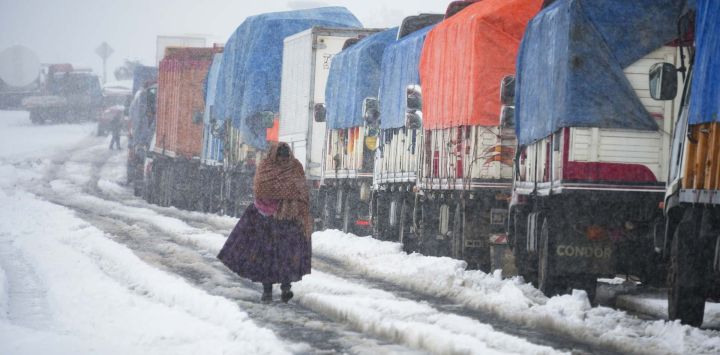 Una indígena boliviana camina en una carretera bajo una intensa nevada, en la salida de la ciudad de La Paz, Bolivia. Bolivia marcó una inusual ola de frío que transformó carreteras, ciudades y comunidades en cinco de sus nueve departamentos en escenarios de nieve, hielo y temperaturas bajo cero, con cientos de vehículos varados, pasajeros en las carreteras y restricciones al tránsito en algunas de las principales rutas que conectan el occidente con el centro y el oriente del país.