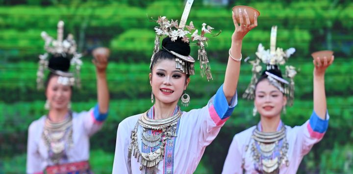 Imagen de actrices realizando una presentación durante un evento promocional, en el distrito autónomo dong de Sanjiang, en el sur de China. Un evento promocional para operadores turísticos se llevó a cabo aquí el jueves, en el que se exhibieron la cultura étnica y los recursos turísticos de la región mediante espectáculos, un tradicional "Banquete de las Cien Familias" y otras actividades.
