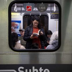 Una mujer lee un libro a bordo de un vagón de la Línea H del metro en el marco del Día del Lector en conmemoración del 127 aniversario del nacimiento del escritor Jorge Luis Borges, en la ciudad de Buenos Aires, capital de Argentina. | Foto:Xinhua/Martín Zabala