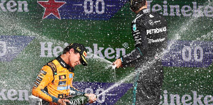 El piloto británico de McLaren (P1), Lando Norris, y el piloto británico de Mercedes (P3), George Russell, rocían champán mientras celebran en el podio tras el Gran Premio de los Países Bajos de Fórmula 1 en el Circuito de Zandvoort, al oeste de los Países Bajos.