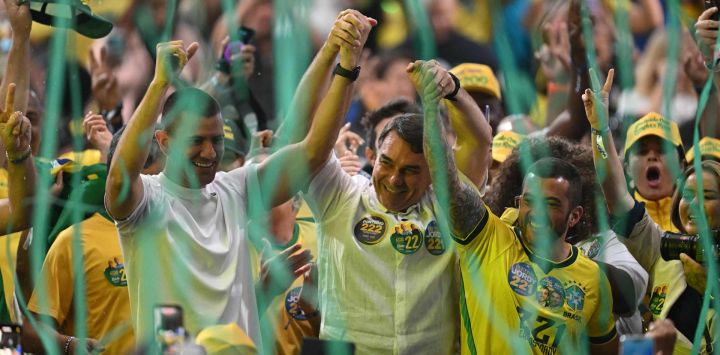 El senador brasileño Flavio Bolsonaro se da la mano con el diputado Douglas Ruas y el diputado Carlos Jordy durante un acto de su campaña presidencial en el gimnasio Maracanazinho de Río de Janeiro, Brasil.
