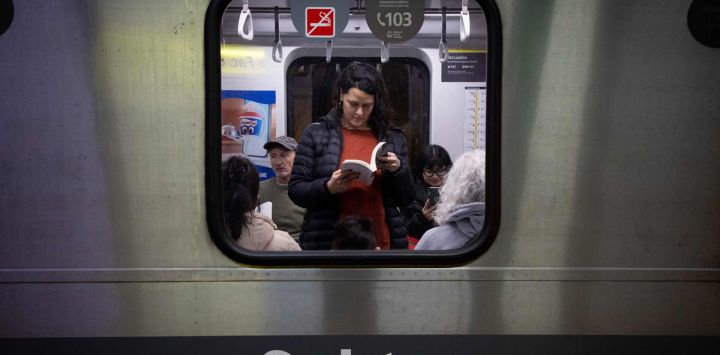 Una mujer lee un libro a bordo de un vagón de la Línea H del metro en el marco del Día del Lector en conmemoración del 127 aniversario del nacimiento del escritor Jorge Luis Borges, en la ciudad de Buenos Aires, capital de Argentina.