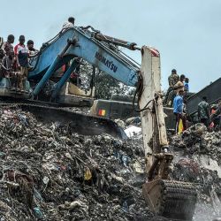 Residentes y rescatistas utilizan una excavadora para buscar cuerpos tras un deslizamiento de tierra ocurrido en el vertedero de Dar es Salaam, en Conakry. Treinta personas murieron y seis resultaron gravemente heridas en las afueras de Conakry, la capital de Guinea, luego de que una montaña de basura en un vertedero se derrumbara sobre viviendas tras las fuertes lluvias, según un comunicado del gobierno. | Foto:AFP