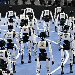 Robots humanoides participan en la ceremonia de apertura de los II Juegos Mundiales de Robots Humanoides en Pekín, China. | Foto:PEDRO PARDO / AFP