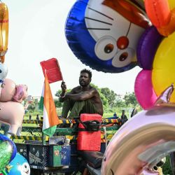 Un vendedor de globos inflados usa un abanico mientras espera clientes en Amritsar, India. | Foto:Narinder Nanu / AFP