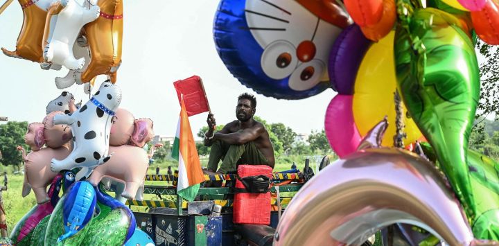 Un vendedor de globos inflados usa un abanico mientras espera clientes en Amritsar, India.