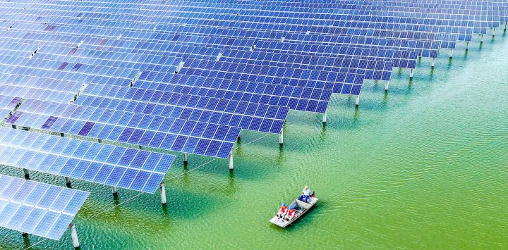 Vista aérea tomada con un dron de trabajadores de mantenimiento patrullando un proyecto híbrido de acuicultura y energía fotovoltaica, en Yangzhou, en la provincia de Jiangsu, en el este de China.