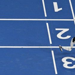 Un robot humanoide pasa corriendo junto a un competidor caído en la carrera de 400 metros durante el segundo día de los II Juegos Mundiales de Robots Humanoides en Pekín. | Foto:PEDRO PARDO / AFP