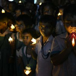 Estudiantes de una escuela sostienen velas LED mientras se reúnen para rendir homenaje a las personas que murieron en las inundaciones repentinas de Nepal, en Chennai, India. | Foto:R. Satish Babu / AFP