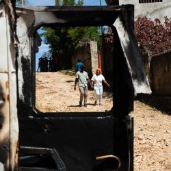 Varias personas caminan junto a los restos de un vehículo incendiado tras la violencia ocurrida durante la noche en Kenscoff, un barrio cercano a Puerto Príncipe, Haití, donde más de veinte personas fueron asesinadas por bandas armadas. Miembros de las bandas atacaron a personas desplazadas que se refugiaban en una iglesia cerca de la capital haitiana, matando a unas 40, algunas de ellas ejecutadas, según informó el alcalde a la AFP. | Foto:Clarens Siffroy / AFP