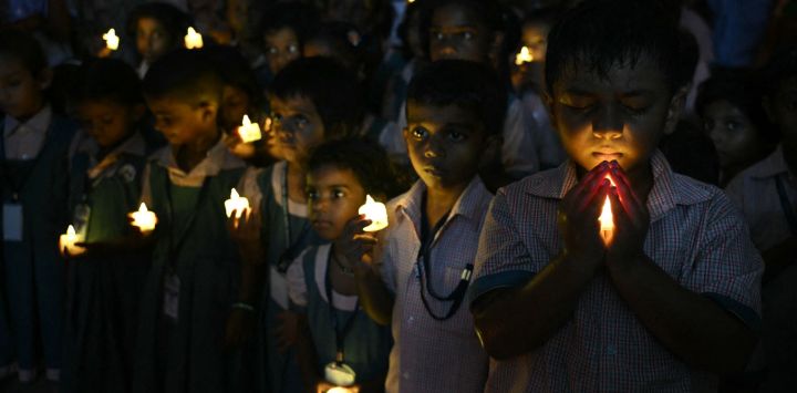 Estudiantes de una escuela sostienen velas LED mientras se reúnen para rendir homenaje a las personas que murieron en las inundaciones repentinas de Nepal, en Chennai, India.