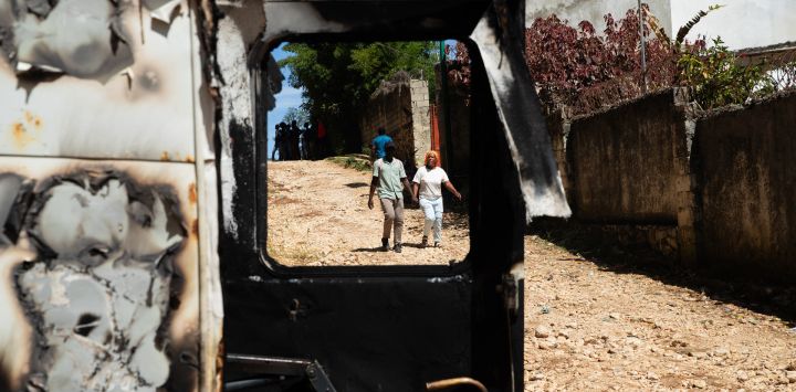 Varias personas caminan junto a los restos de un vehículo incendiado tras la violencia ocurrida durante la noche en Kenscoff, un barrio cercano a Puerto Príncipe, Haití, donde más de veinte personas fueron asesinadas por bandas armadas. Miembros de las bandas atacaron a personas desplazadas que se refugiaban en una iglesia cerca de la capital haitiana, matando a unas 40, algunas de ellas ejecutadas, según informó el alcalde a la AFP.
