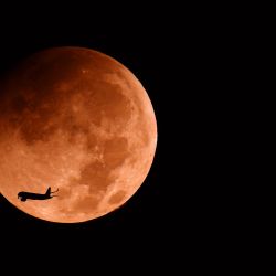 La Luna comienza su fase penumbral durante un eclipse lunar parcial sobre la ciudad costera israelí de Netanya. | Foto:JACK GUEZ / AFP