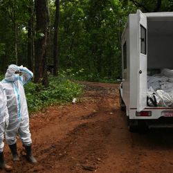 Personal de seguridad se encuentra junto a un camión que transporta los cuerpos de víctimas no identificadas de las inundaciones, en una fosa común en Devghat, en el distrito de Chitwan, Nepal. Al menos 4471 personas figuraban como desaparecidas y otras 955 fueron confirmadas como fallecidas tras las inundaciones repentinas y los deslizamientos de tierra que azotaron la frontera con Nepal. | Foto:PRAKASH MATHEMA / AFP