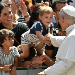 El papa León XIV saluda a un niño entre la multitud tras el rezo del Ángelus a la entrada del Palacio Apostólico en la Piazza della Libertà (Plaza de la Libertad), en la residencia papal de verano de Castel Gandolfo. | Foto:ALBERTO PIZZOLI / AFP
