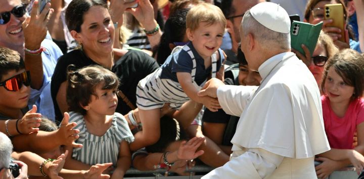 El papa León XIV saluda a un niño entre la multitud tras el rezo del Ángelus a la entrada del Palacio Apostólico en la Piazza della Libertà (Plaza de la Libertad), en la residencia papal de verano de Castel Gandolfo.