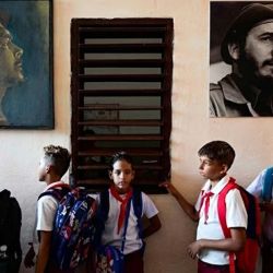Estudiantes hacen fila junto a los retratos de figuras históricas como Ernesto "Che" Guevara y Fidel Castro antes de entrar a sus aulas en su primer día del ciclo escolar 2026-2027 en La Habana. En medio de la escasez de uniformes, la falta de maestros y los prolongados cortes de energía, 1,4 millones de estudiantes comenzaron un nuevo año escolar en Cuba, donde la crisis económica obliga a las familias a asumir los crecientes costos de la educación de sus hijos. | Foto:YAMIL LAGE / AFP