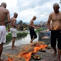 Familiares realizan ritos hindúes nepalíes para la cremación de efigies de hierba Kush durante funerales simbólicos celebrados en honor a las víctimas de las inundaciones que aún permanecen desaparecidas, en el templo Pashupatinath de Katmandú. | Foto:PRAKASH MATHEMA / AFP