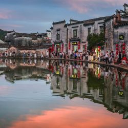 Imagen de turistas visitando un estanque al atardecer, en la aldea de Hongcun, en la provincia de Anhui, en el este de China. | Foto:Xinhua/Chang Nengjia