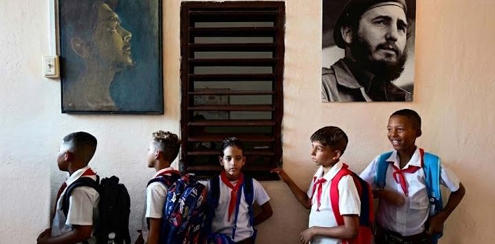 Estudiantes hacen fila junto a los retratos de figuras históricas como Ernesto "Che" Guevara y Fidel Castro antes de entrar a sus aulas en su primer día del ciclo escolar 2026-2027 en La Habana. En medio de la escasez de uniformes, la falta de maestros y los prolongados cortes de energía, 1,4 millones de estudiantes comenzaron un nuevo año escolar en Cuba, donde la crisis económica obliga a las familias a asumir los crecientes costos de la educación de sus hijos.