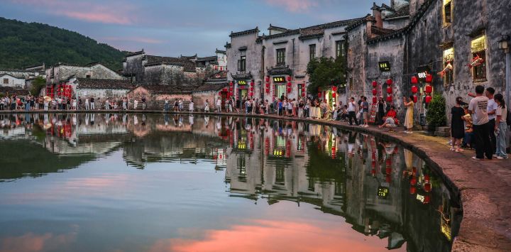 Imagen de turistas visitando un estanque al atardecer, en la aldea de Hongcun, en la provincia de Anhui, en el este de China.