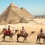 Fotogaleria Imagen de turistas montando camellos en el complejo de las pirámides de Giza, en Egipto. Egipto es la cuna de una antigua civilización que floreció a lo largo del río Nilo