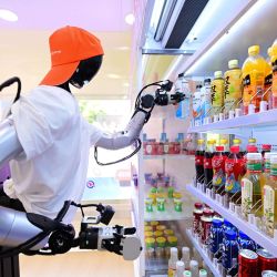 Un robot toma una botella de bebida de un estante en una tienda de robots de inteligencia incorporados en la calle Leijie, en Hefei, en la provincia de Anhui, en el este de China. Cuatro tiendas de robots de inteligencia incorporados equipadas con robots humanoides con ruedas que actúan como dependientes han abierto oficialmente en diversas zonas culturales, turísticas y comerciales de Hefei. Estos robots dependientes son capaces de reconocer, agarrar y entregar mercancías a los clientes de forma automática. | Foto:Xinhua/Zhou Mu