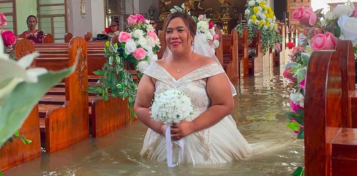 Esta fotografía muestra a la novia Leian Lieza Galang caminando hacia el altar durante su ceremonia nupcial en una iglesia inundada en el municipio de Hagonoy, Filipinas. Una pareja filipina contrajo matrimonio en una iglesia católica anegada con agua hasta la cintura, debido a las fuertes lluvias que han azotado gran parte del país durante un mes.