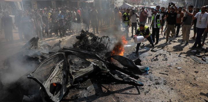 Un palestino extingue un incendio en un vehículo destruido después de un ataque con dron israelí, en el barrio de Tel al-Hawa, en la Ciudad de Gaza. Tres palestinos murieron en un ataque israelí contra un vehículo en la Ciudad de Gaza, de acuerdo con fuentes médicas palestinas.